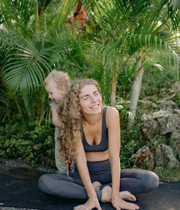 Happy child in a playful yoga pose on a colorful mat.